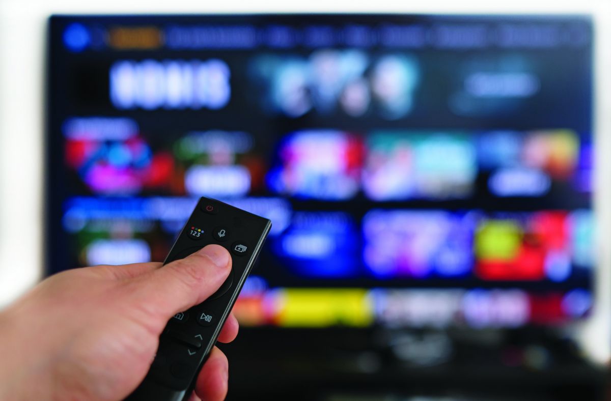 Person using remote to pick something to watch on TV.